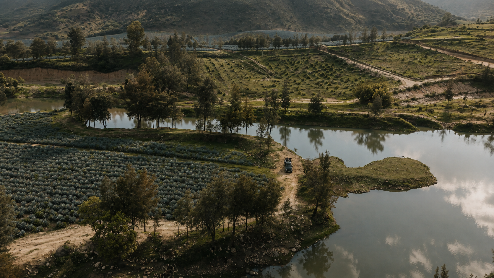 Paisaje real de uno de los lagos de Monte Lago, con terreno y caminos del desarrollo.